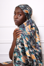 Load image into Gallery viewer, woman wearing a large zebra print scarf as a headwrap
